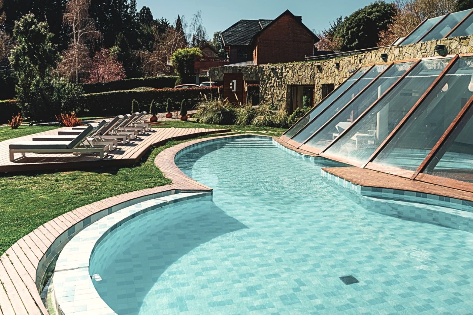 Piscina de Rochester Bariloche con techo de vidrio y jardín